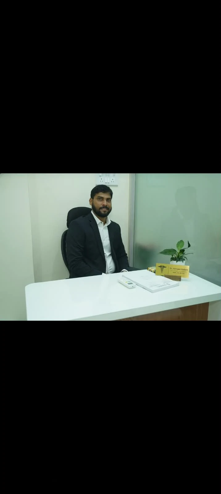 Dr. Abhijeet Kadam seated at his consulting desk in the Seawoods clinic